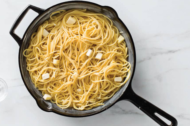 Eine Pfanne gefüllt mit Spaghetti und Käse, eine köstliche und wohltuende Mahlzeit.