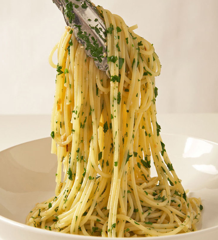 Spaghetti mit Knoblauch und Öl auf einem Teller mit einer silbernen Gabel.