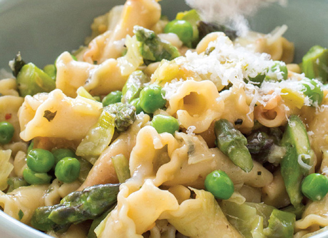 Nahaufnahme einer Schüssel Pasta mit Spargel und Erbsen, bekannt als Pasta Primavera.