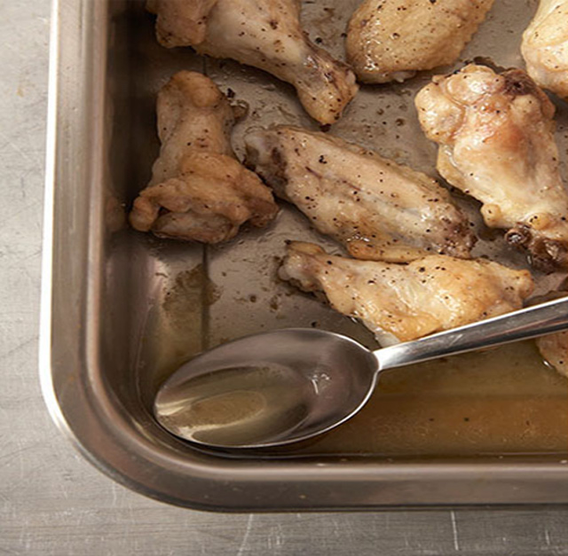 Nehmen Sie einen Löffel der Chicken Wings Buffalo Style Brühe in das Tablett