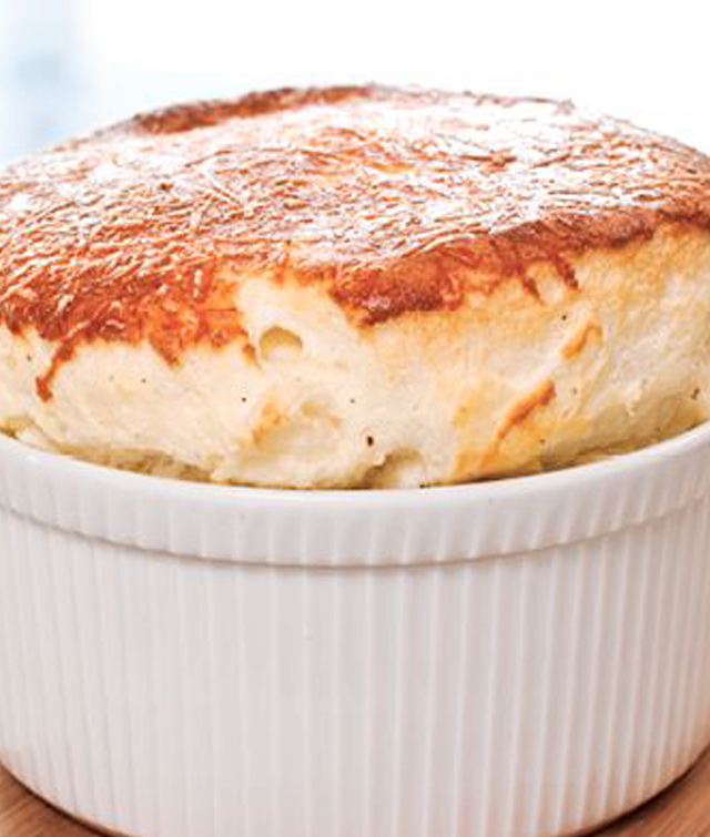 Ein weißer Teller mit Käse-Soufflé, appetitlich angerichtet und bereit zum Servieren.