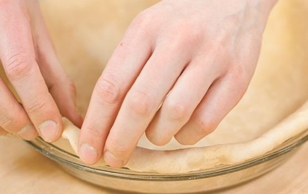 Eine Person rollt mit den Händen einen Teig für eine Torte aus und bereitet sich auf das Backen vor.