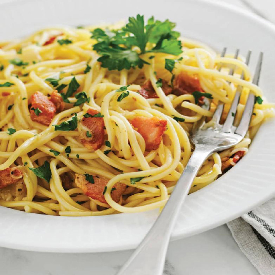 SPAGHETTI Carbonara topped with crispy bacon and fresh parsley.