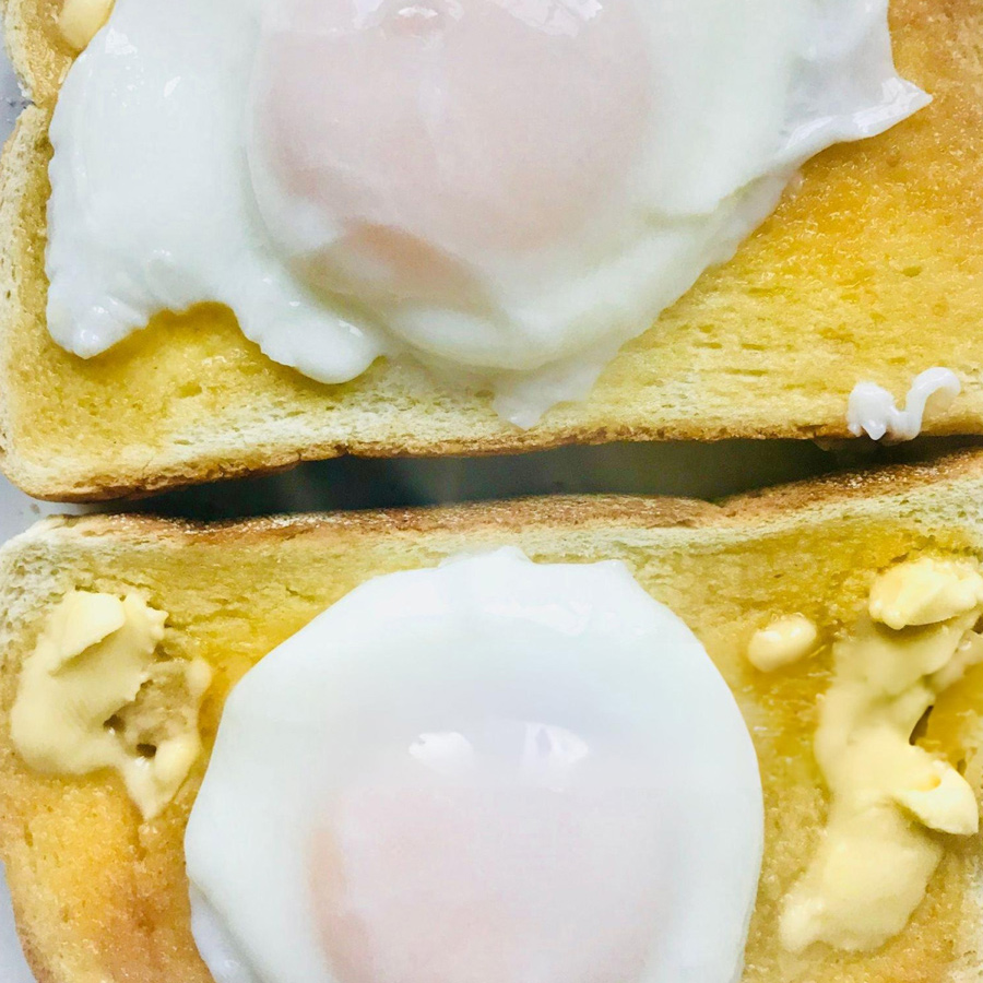 Pochierte Eier auf Toast legen