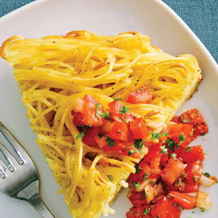 Frittata di Spaghetti slice topped with tomatoes and cheese on a plate.